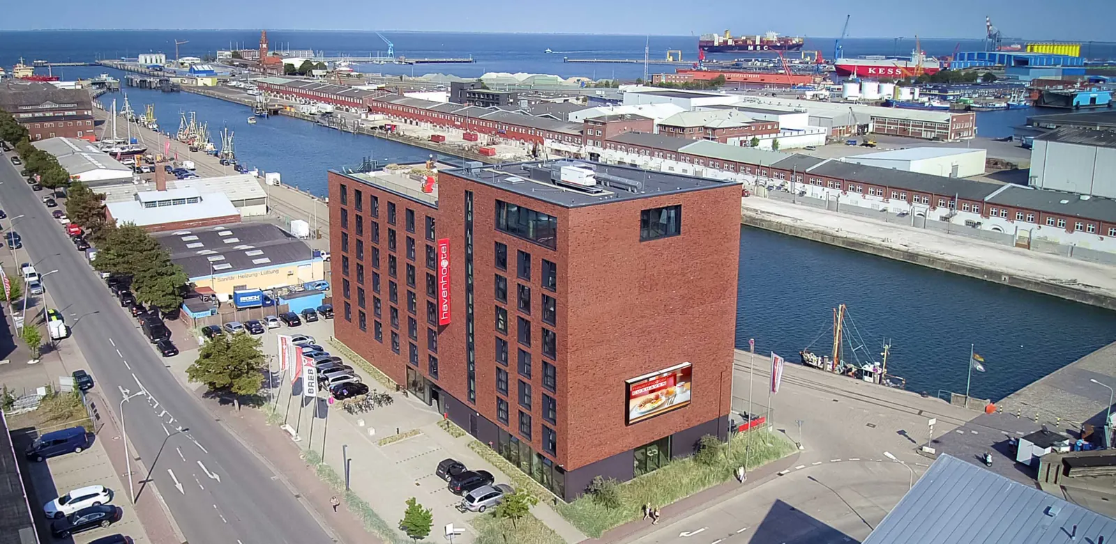 Luftbild: das rote Klinkergebäude des havenhostel am Hafenbecken in Cuxhaven